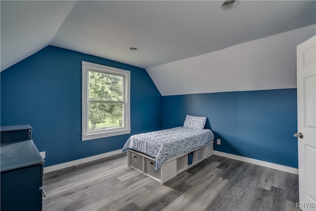 bedroom with vaulted ceiling and wood-type flooring