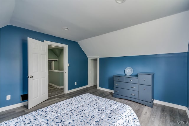 bedroom with vaulted ceiling and wood-type flooring