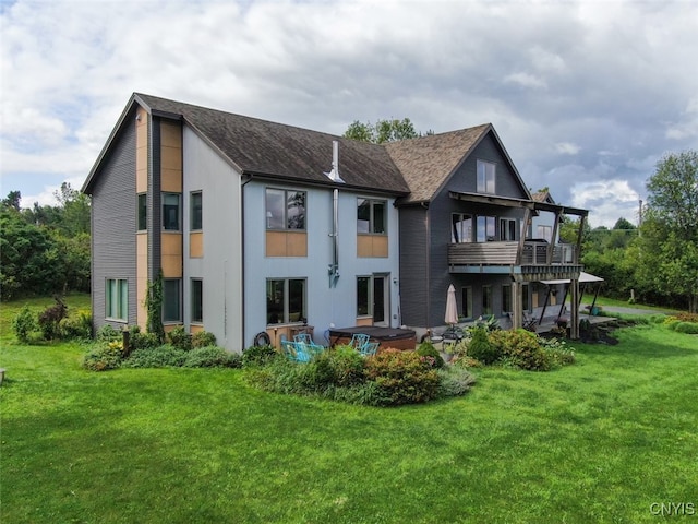 back of house featuring a balcony and a lawn