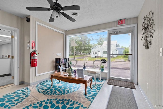 living area featuring ceiling fan, a textured ceiling, and light tile patterned floors