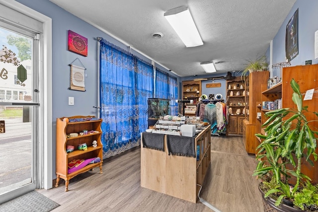 interior space featuring a textured ceiling and wood-type flooring