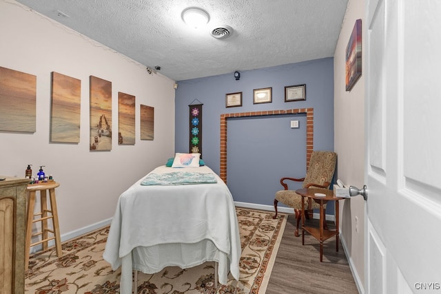 bedroom featuring a textured ceiling and wood-type flooring