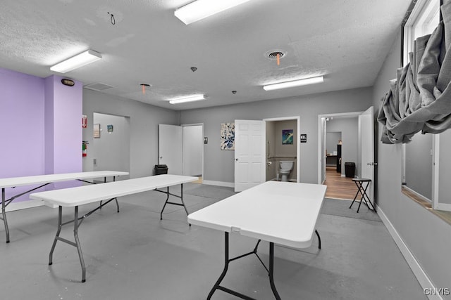 recreation room with a textured ceiling