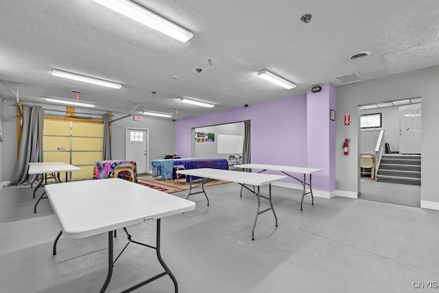 recreation room featuring a textured ceiling