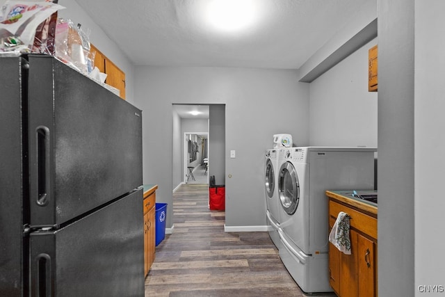 clothes washing area featuring washer and dryer and dark hardwood / wood-style floors