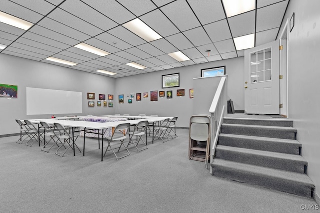 carpeted dining area featuring a drop ceiling