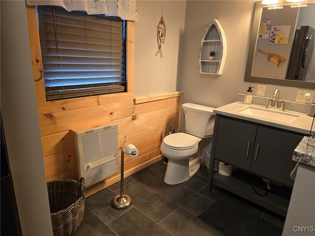 bathroom featuring heating unit, toilet, tile patterned flooring, and vanity