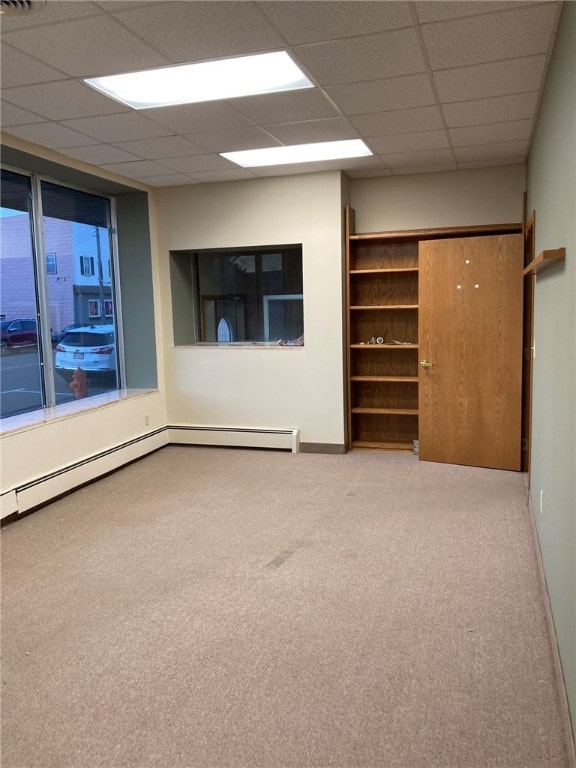 spare room featuring carpet flooring and a paneled ceiling