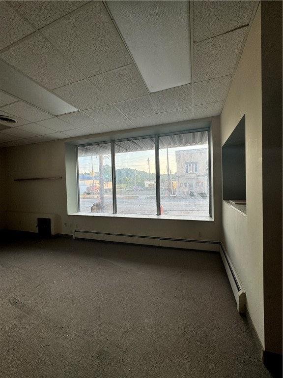 spare room featuring carpet and a paneled ceiling