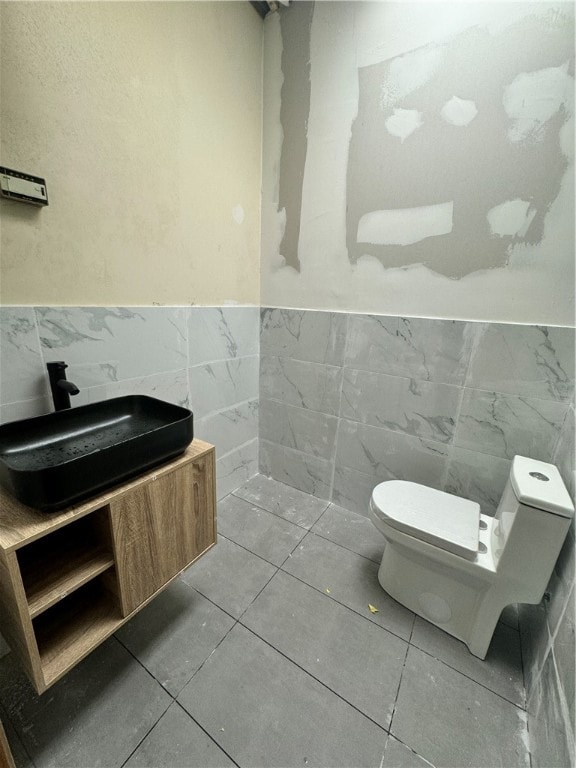 bathroom with tile walls, tile patterned flooring, and toilet