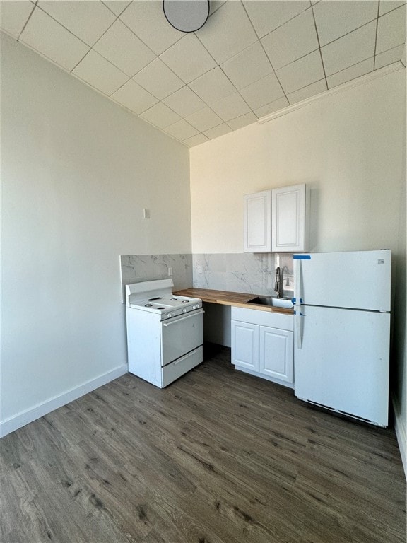 kitchen with backsplash, sink, dark wood-type flooring, white appliances, and white cabinets