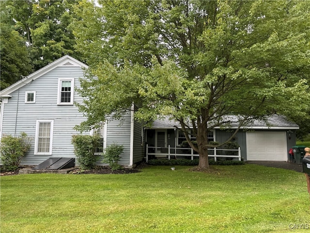 back of property with a sunroom, a garage, and a yard