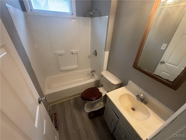 full bathroom with bathing tub / shower combination, toilet, hardwood / wood-style floors, and vanity