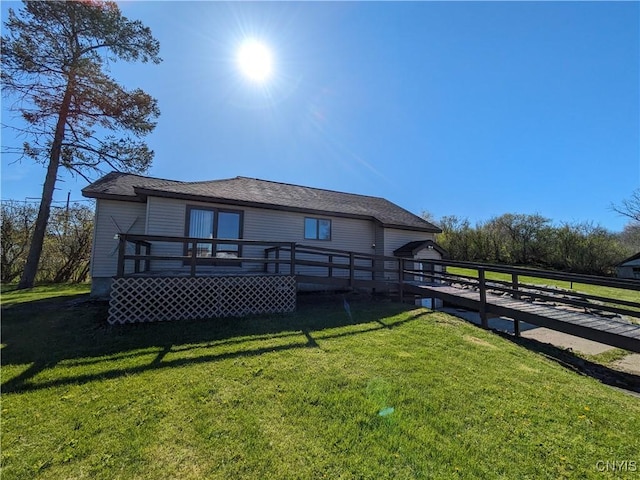 back of property with a deck and a lawn