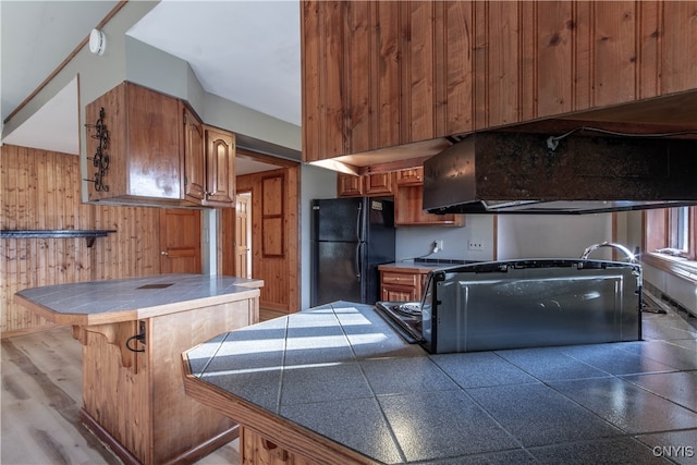 kitchen with light hardwood / wood-style flooring and black fridge