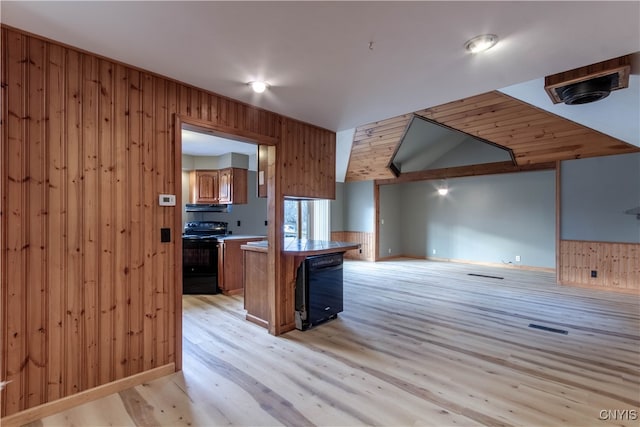 kitchen featuring light hardwood / wood-style floors, range, a kitchen island, and wood walls