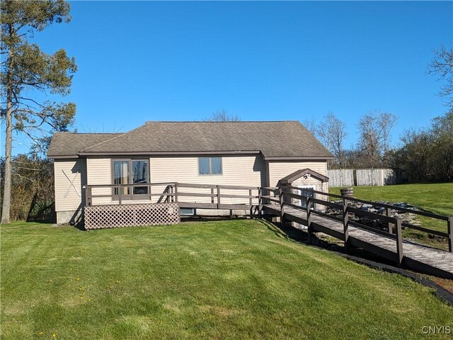 rear view of house with a deck and a lawn