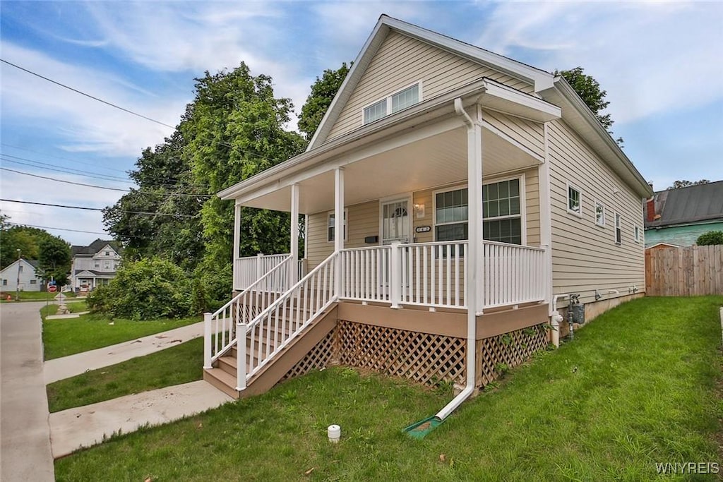 bungalow with a porch, a front yard, and fence