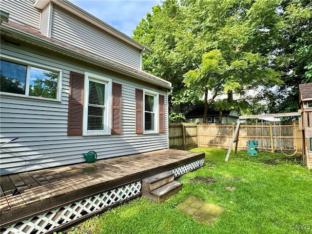 view of property exterior with fence, a deck, and a lawn