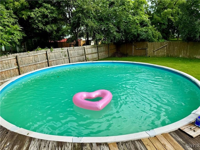 view of pool with a lawn, a fenced backyard, and a fenced in pool