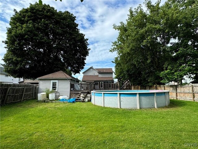 view of pool with a lawn and a shed