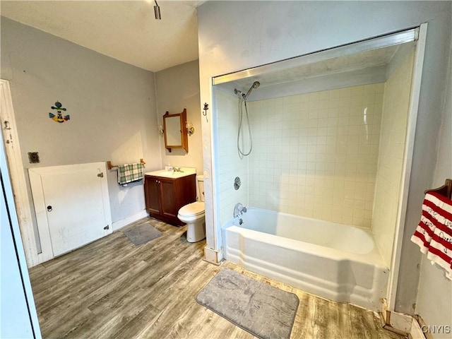 full bathroom with toilet, wood finished floors, vanity, bathing tub / shower combination, and baseboards