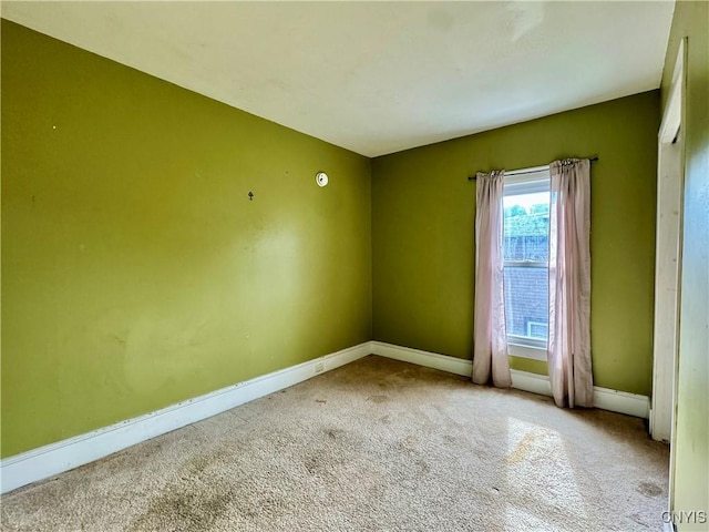 carpeted empty room with baseboards