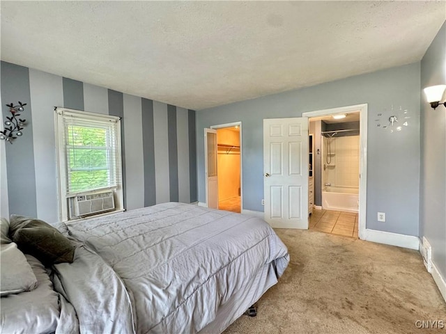 bedroom with baseboards, ensuite bathroom, carpet, a spacious closet, and cooling unit