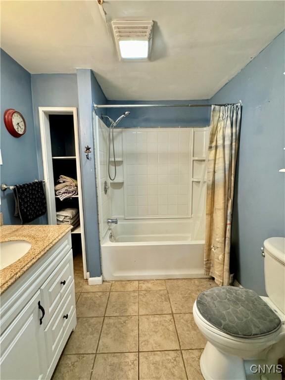 full bathroom featuring tile patterned floors, vanity, toilet, and shower / bathtub combination with curtain