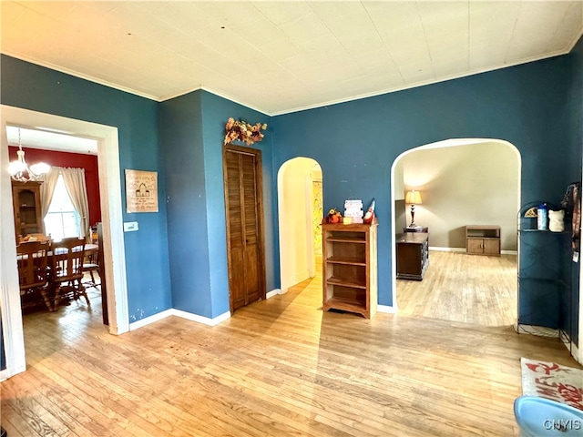 bedroom featuring wood-type flooring, a notable chandelier, and ornamental molding