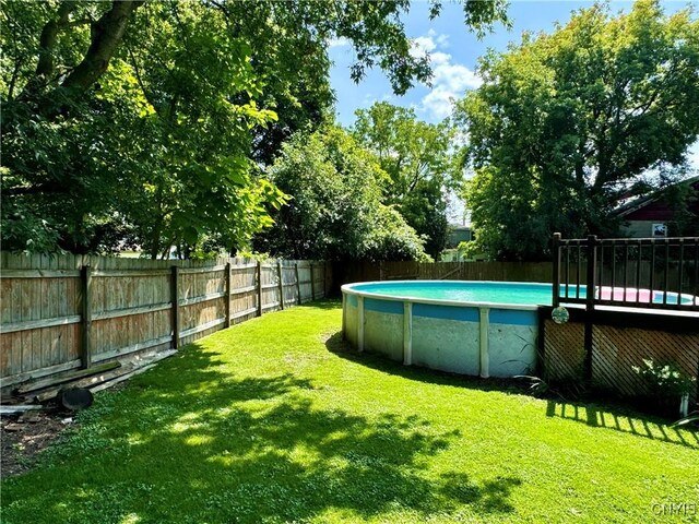 view of yard with a fenced in pool