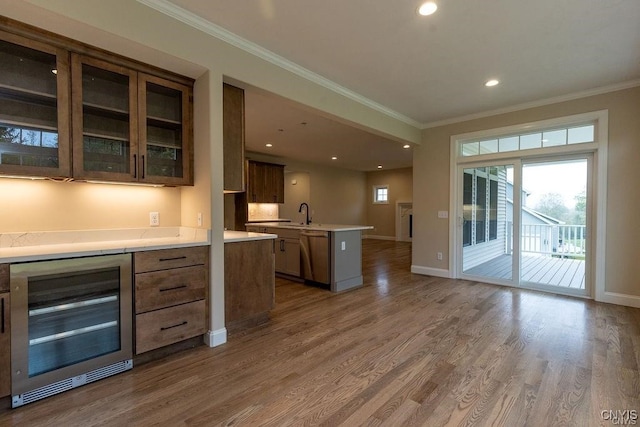 kitchen featuring beverage cooler, dark wood-type flooring, ornamental molding, and dishwashing machine