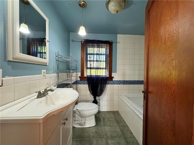 bathroom with toilet, a bath, tile patterned floors, vanity, and tile walls