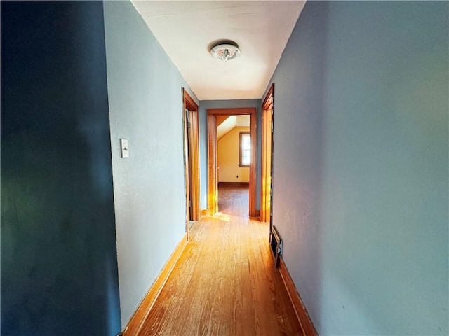 hall featuring baseboards and wood finished floors