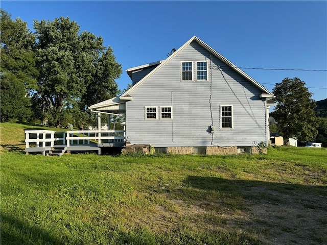 view of side of property with a deck and a yard