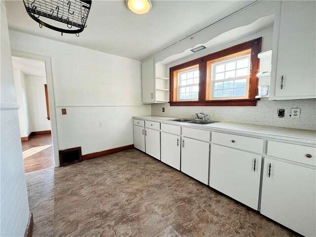 kitchen with sink, light hardwood / wood-style flooring, and white cabinetry