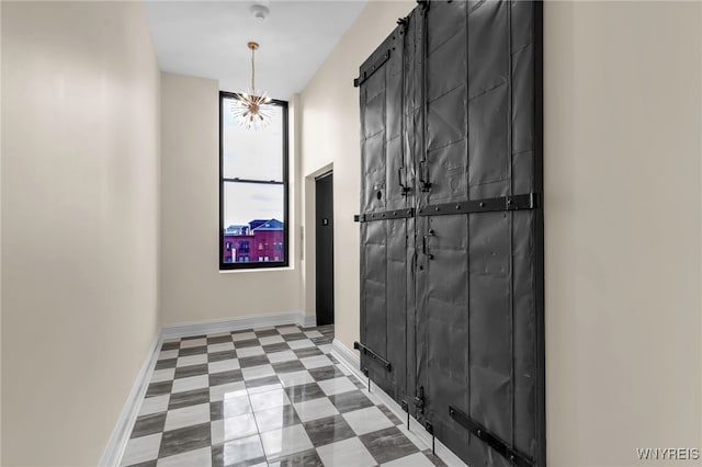 mudroom with a barn door, tile patterned floors, and a chandelier