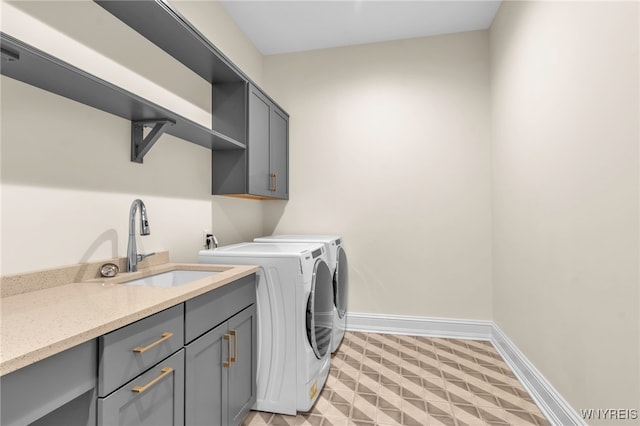 laundry room with sink, light tile patterned flooring, cabinets, and washing machine and clothes dryer