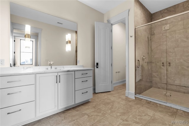 bathroom with tile patterned flooring, vanity, and walk in shower