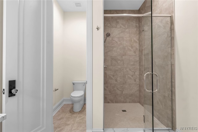 bathroom with toilet, tile patterned flooring, and a shower with shower door