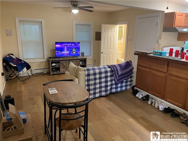 interior space with light hardwood / wood-style floors, baseboard heating, and ceiling fan