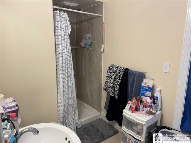 bathroom with tile patterned flooring, sink, and curtained shower