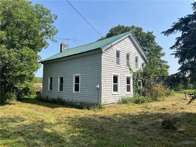 view of side of home with a lawn