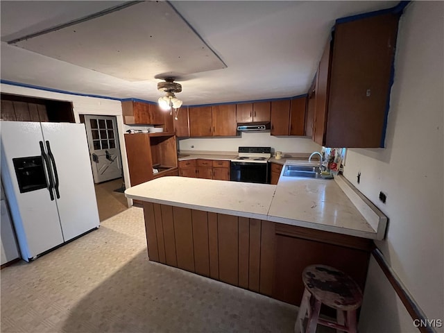 kitchen featuring sink, white appliances, range hood, light tile patterned floors, and kitchen peninsula