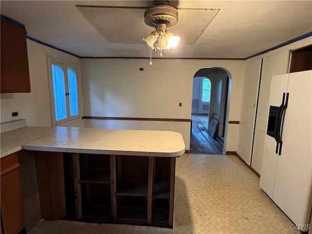 kitchen with kitchen peninsula, ceiling fan, and white refrigerator with ice dispenser