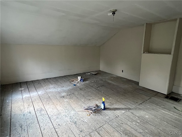 additional living space featuring vaulted ceiling and hardwood / wood-style floors