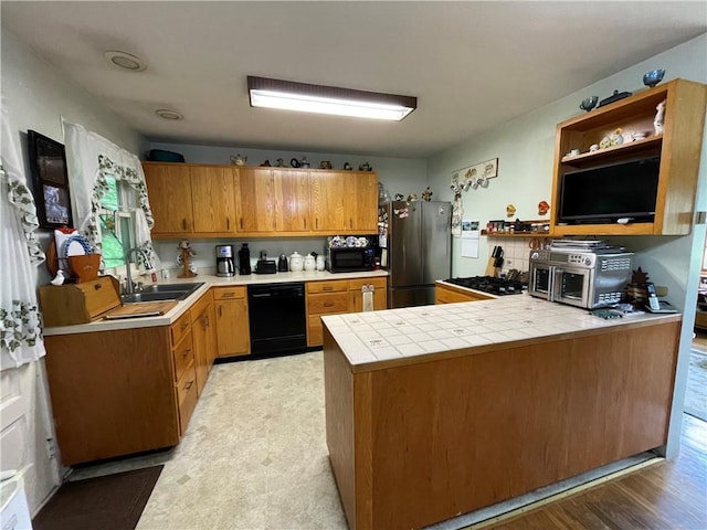 kitchen featuring kitchen peninsula, sink, black appliances, light hardwood / wood-style flooring, and tile counters