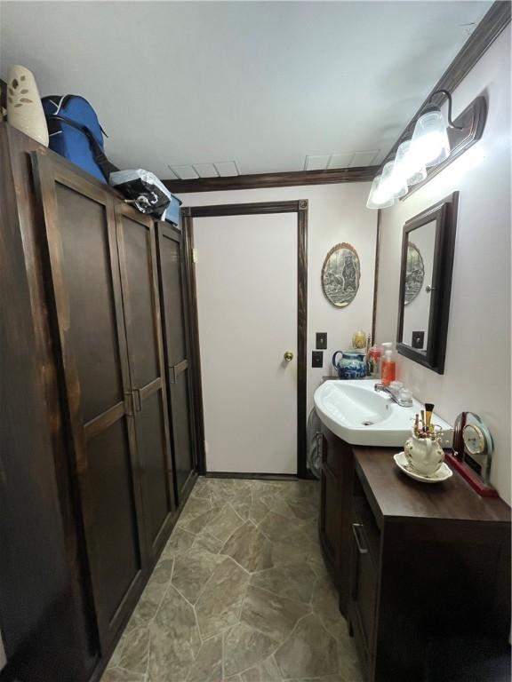 bathroom with vanity and ornamental molding