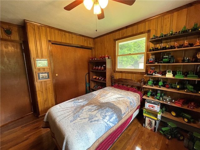 bedroom featuring vaulted ceiling, ceiling fan, crown molding, dark wood-type flooring, and wood walls