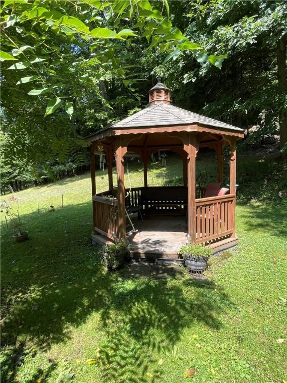 view of property's community featuring fence, a lawn, and a gazebo